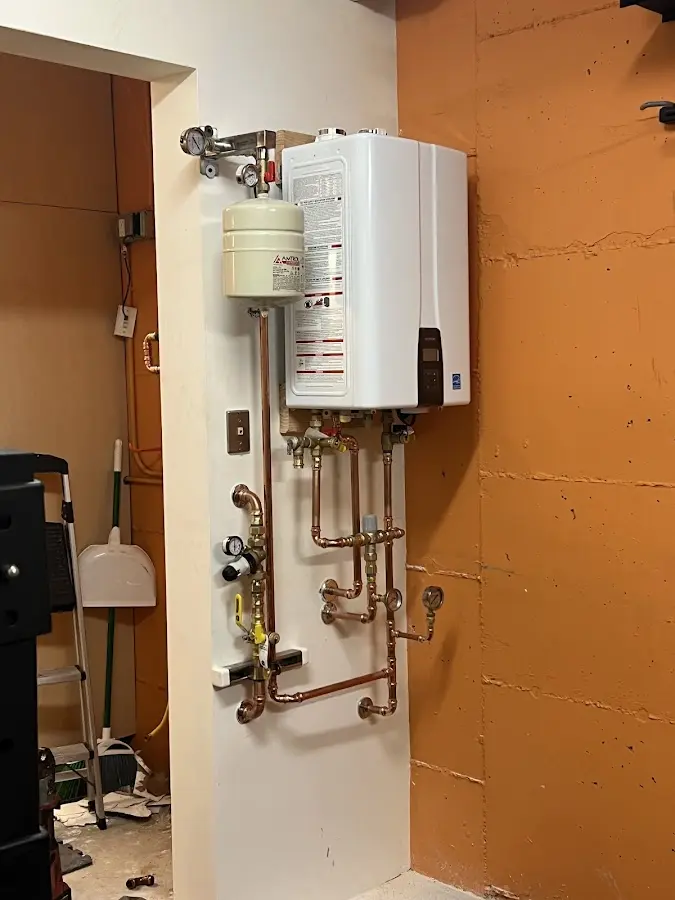 Plumbing technician inspecting water heater connections in Los Banos